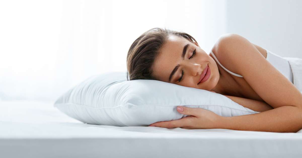 A woman with a lip filler injection lying on the bed with an elevated pillow.