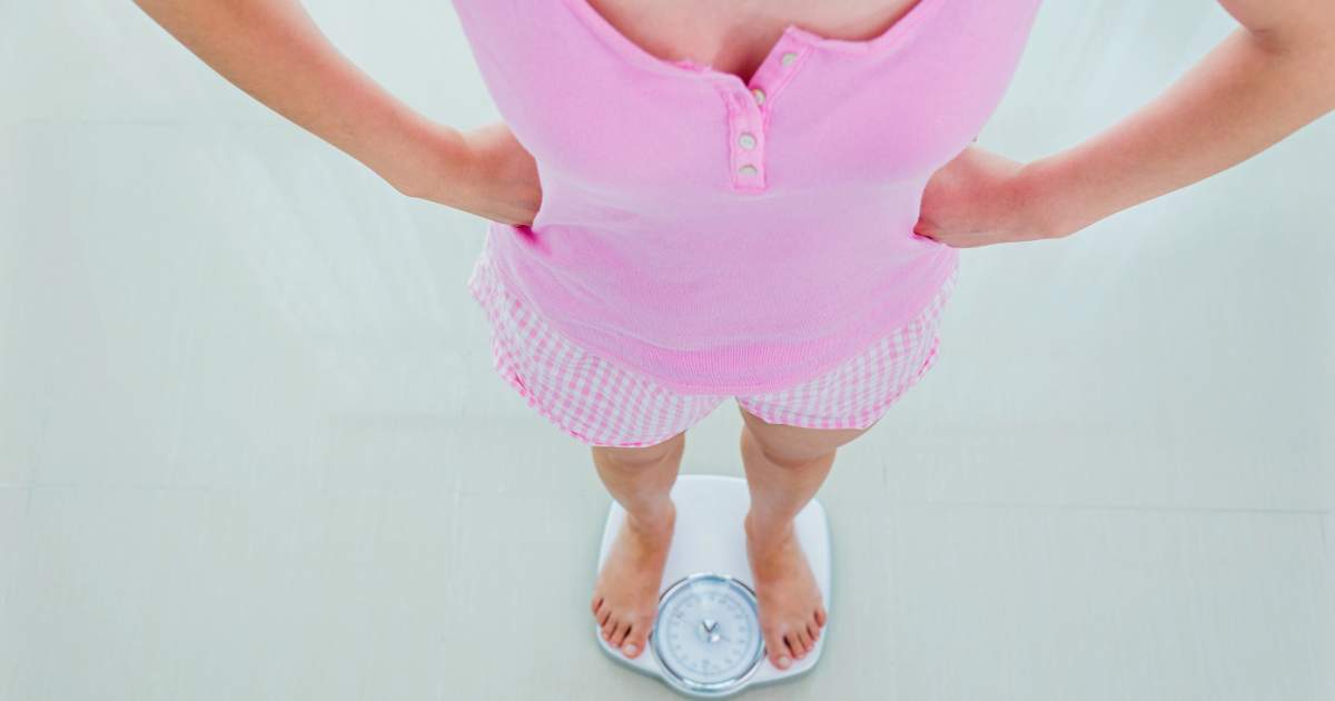 A woman standing on a weighing scale.