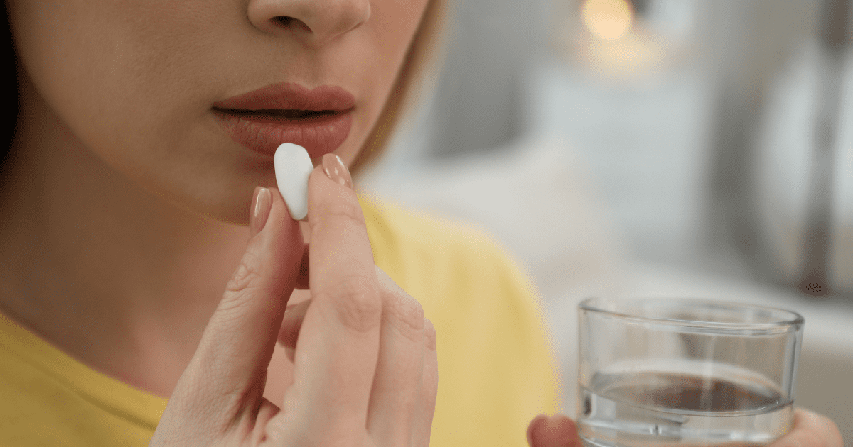 A woman taking a tablet.